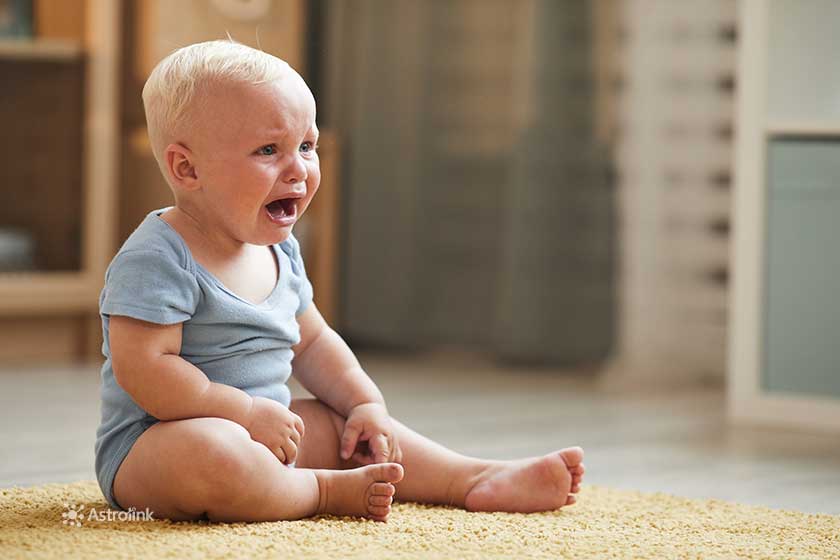 baby sitting on the floor crying